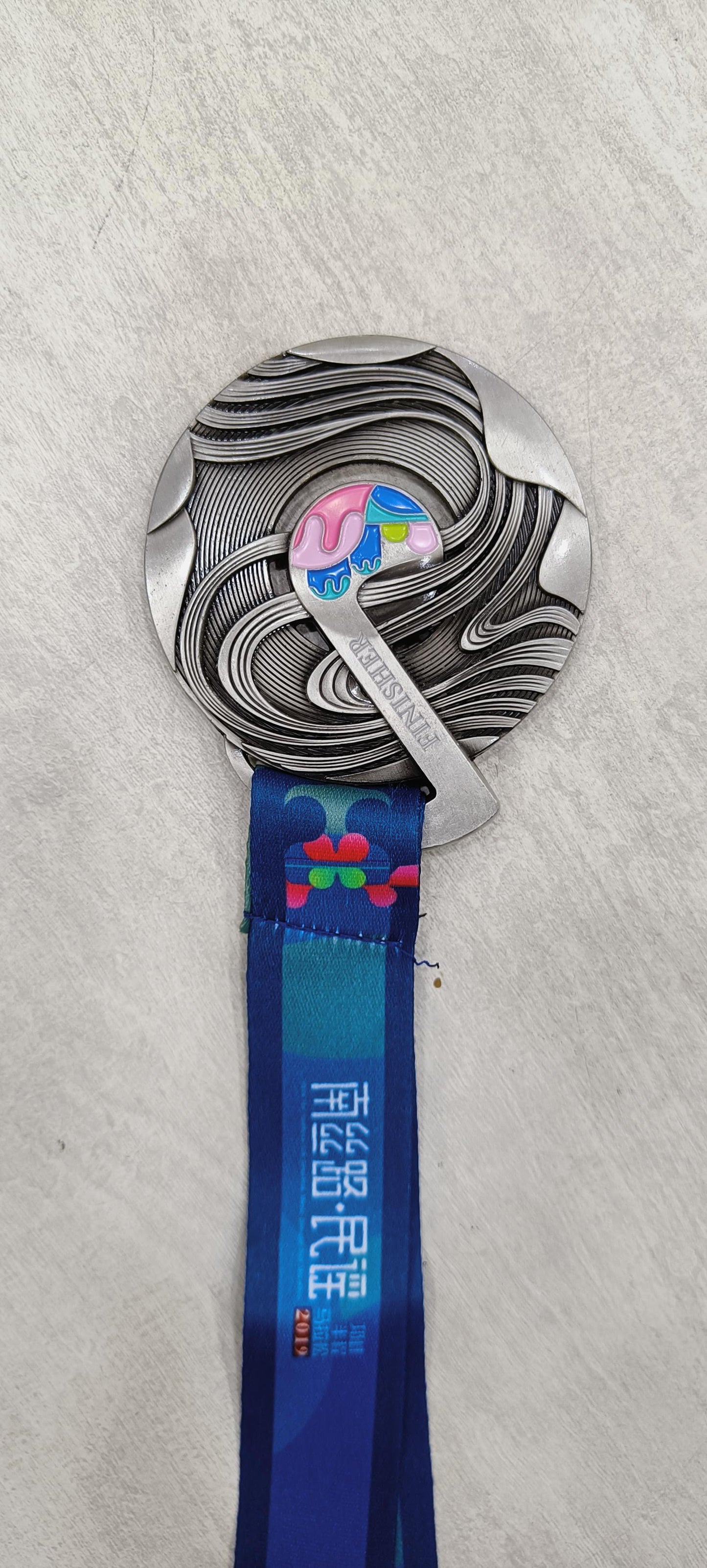 Silver finisher medal with colorful accents and blue lanyard.  Perfect for sports prizes or corporate awards.