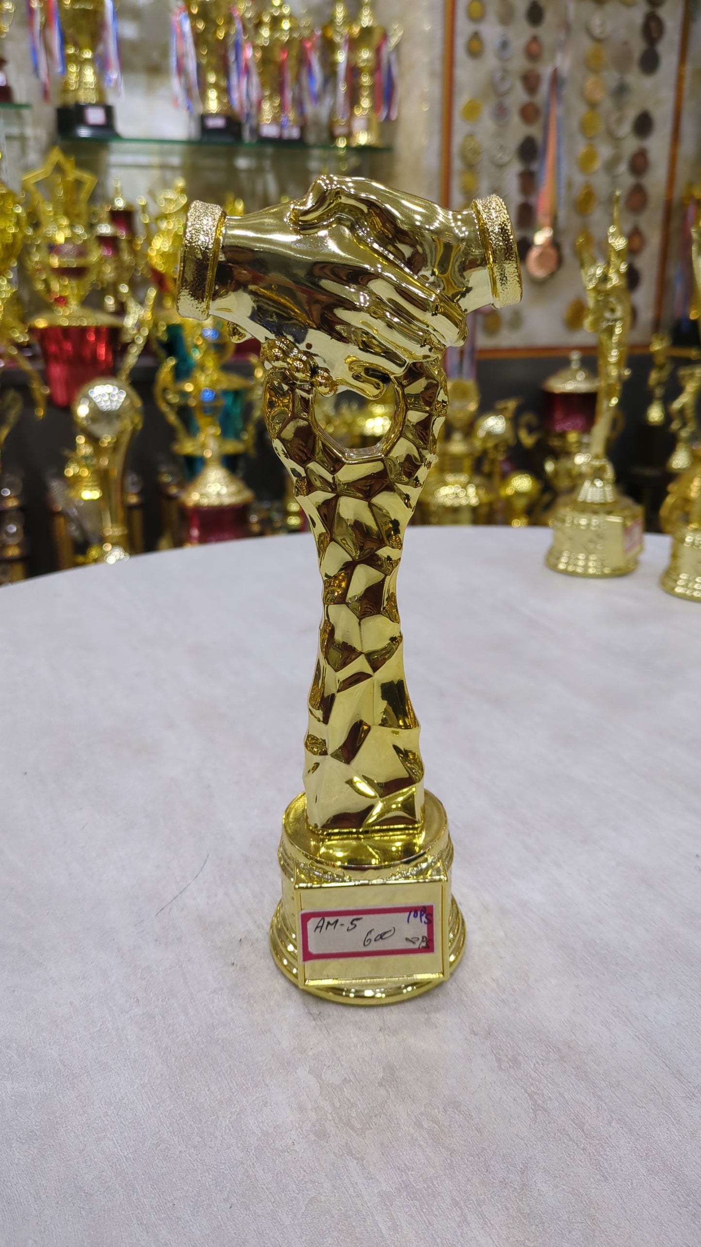 Gold handshake trophy; a symbol of corporate recognition and awards.